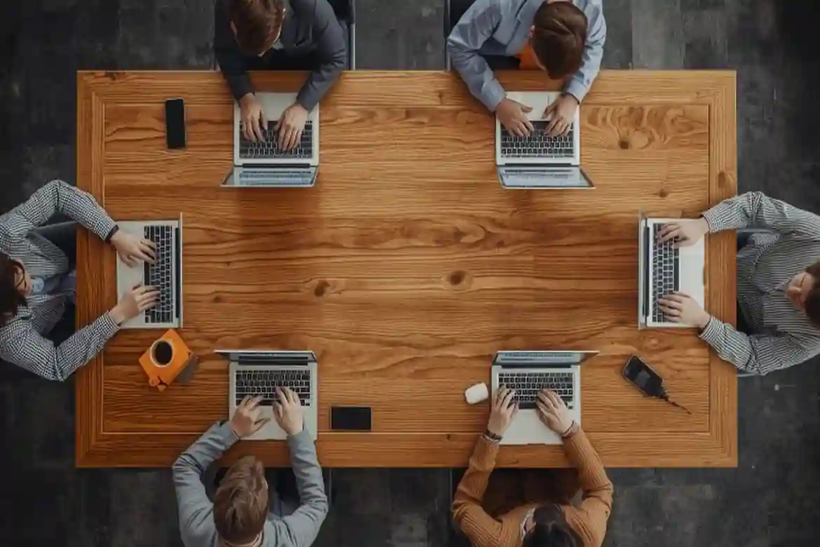 A team collaborating on laptops around a shared table, representing hands‑on learning in a Digital Marketing Bootcamp.